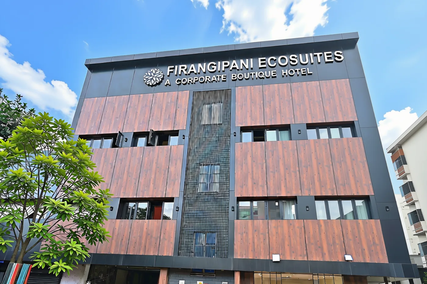 Hotel facade with Firangipani Ecosuites signage in New Town, Kolkata