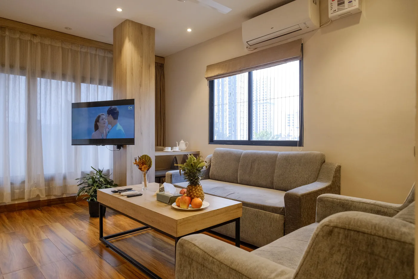 Luxury Suite lounge with a sofa, coffee table and large windows beside the bed