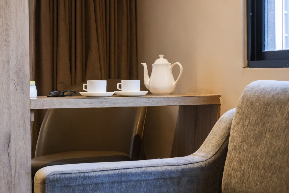 Teapot and cups on a coffee table beside the suite sofa