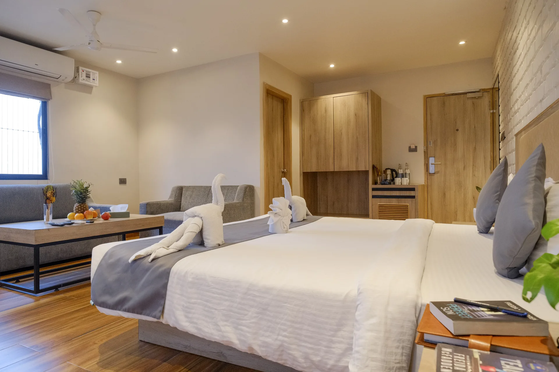 Suite with a double bed, sofa, coffee table and workspace at Firangipani Ecosuites in New Town, Kolkata