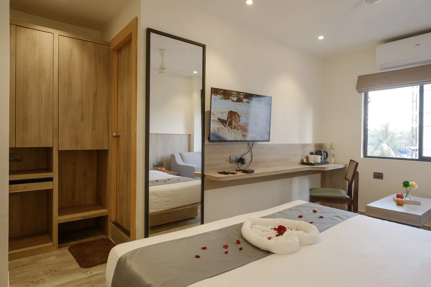Junior Suite interior with a desk, TV and wardrobe opposite the bed